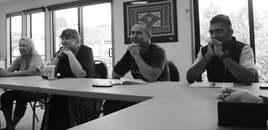 Black and white photo of four engaged people at Talk Business Networking