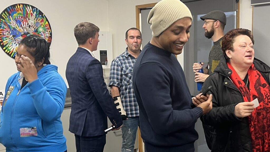 Diverse group of people laughing and chatting after a Talk Business Networking session.